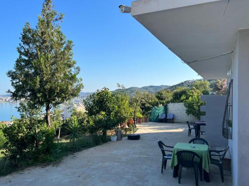 a patio with tables and chairs and a view of the water at Markev Apartments in Vlorë