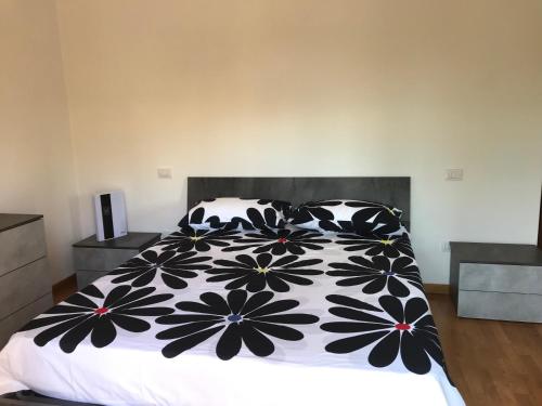 una camera con un letto con una coperta bianca e nera di Casetta in Collina a Castello delle Forme