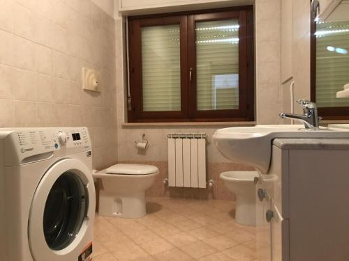 een badkamer met een wasmachine en een wastafel bij Casetta in Collina in Castello delle Forme