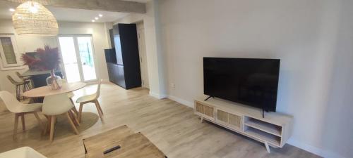 ein Wohnzimmer mit einem Flachbild-TV und einem Tisch in der Unterkunft Logroño Centric in Logroño