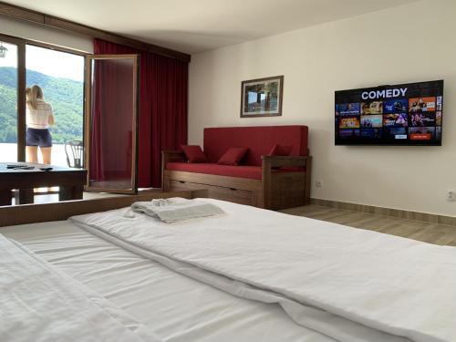 a bedroom with a large bed and a red couch at Dunavska Vila Milosavljevic in Donji Milanovac