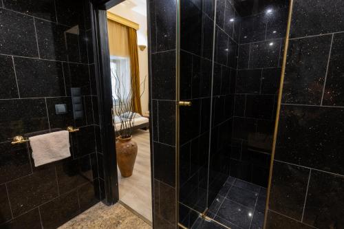 a bathroom with a shower with black tiles at Friends Hostel & Apartments in Budapest