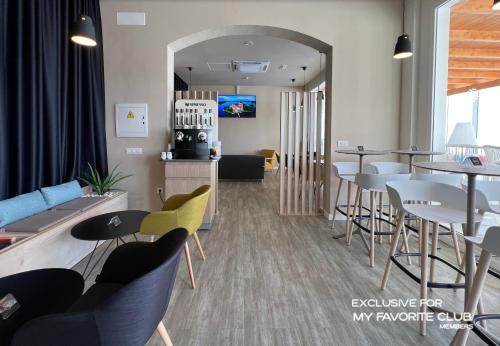 a living room with tables and chairs and a bar at Alua Village Fuerteventura - All Inclusive in Playa Jandia