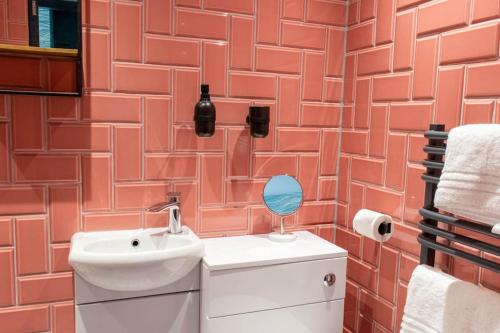 a bathroom with a sink and a red brick wall at High Tide in Redcar