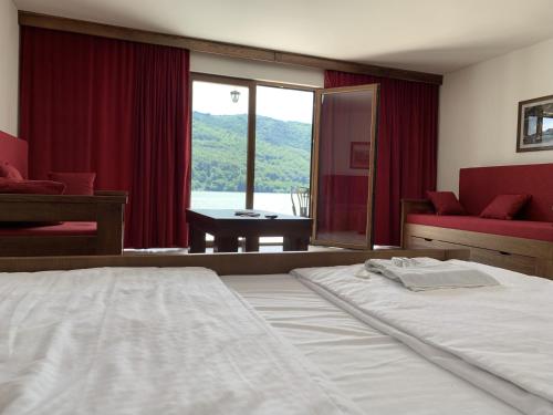 una camera con un grande letto e una grande finestra di Dunavska Vila Milosavljevic a Donji Milanovac