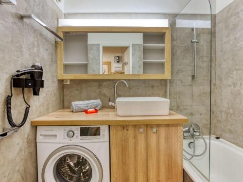 a bathroom with a washing machine and a sink at Apartment Chanteneige 301 by Interhome in Les Menuires