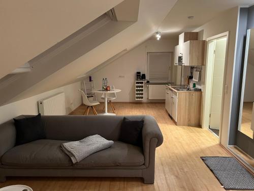 a living room with a couch and a kitchen at Wohlfühl Apartment in Wendelstein