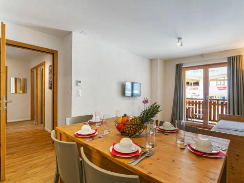 Apartment T-Resort La Tzoumaz 3p6 by Interhome في لا تزوماز: مطبخ وغرفة طعام مع طاولة خشبية