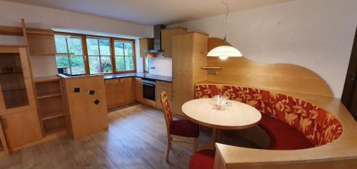 uma cozinha com uma mesa e uma pequena mesa e cadeiras em Berghof Reiter em Weissbriach