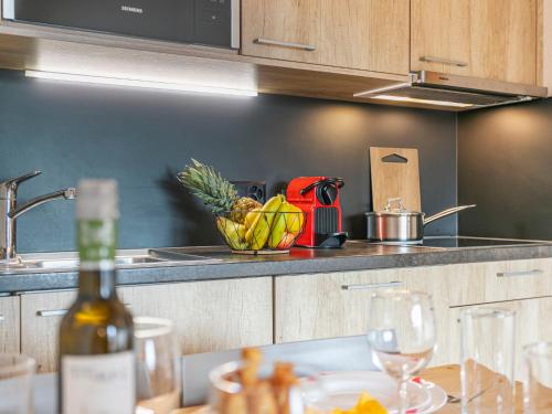 a kitchen with a bowl of fruit and a bottle of wine at Apartment T-Resort La Tzoumaz 2p4 by Interhome in La Tzoumaz