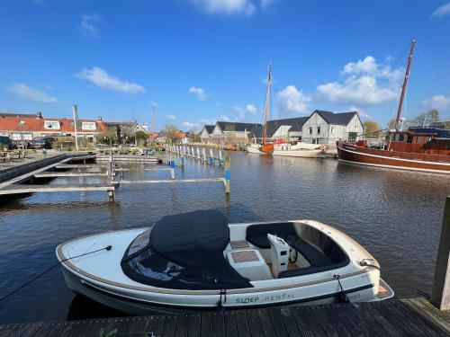 a small boat is docked at a dock at Hotel Workum in Workum