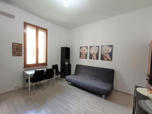 ein Wohnzimmer mit einem Sofa und einem Tisch in der Unterkunft Palagi Suite in Bologna