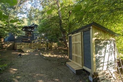a small shed in a yard next to a fence at L'Abri des Rêves in Aydat