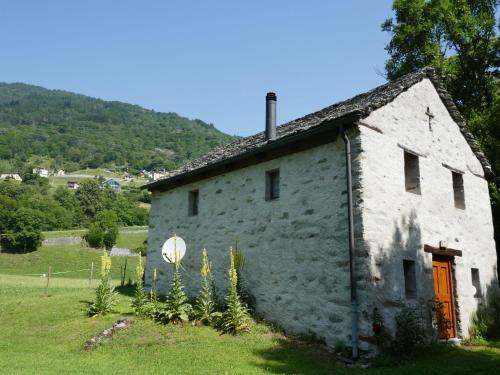 an old stone house in a grassy field at Holiday Home Rustico al Campett by Interhome in Ponto Valentino