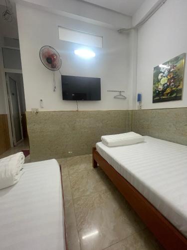 a room with two beds and a flat screen tv at Nhà nghỉ 2552, đường D4 , KDC Võ Thị Sáu , phường Thống Nhất , thành phố Biên Hòa in Bien Hoa