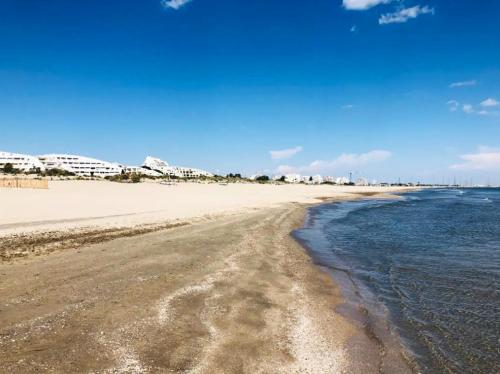 Blick auf den Strand mit Gebäuden im Hintergrund in der Unterkunft Studio charmant & lumineux à La Grande-Motte - 22 m² + Balcon in La Grande-Motte