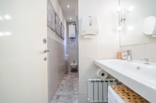 uma casa de banho branca com um lavatório e um WC em Flowersign em Zagreb