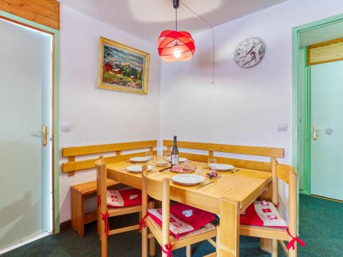 una sala da pranzo con tavolo e sedie in legno di Apartment Chanteneige La Croisette-5 by Interhome a Les Menuires
