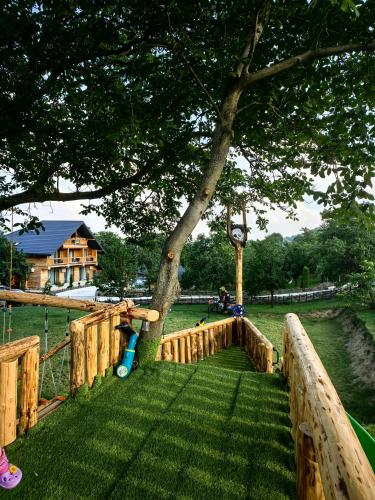 a playground with a tree in a park at Bârlogul Vikingilor in Şotrile
