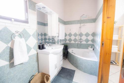 a bathroom with a tub and a sink and a bath tub at Casa con pozo Platamonas in Platamonas