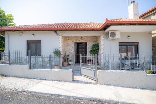 a house with a gate in front of it at Casa con pozo Platamonas in Platamonas
