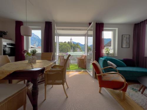 un soggiorno con tavolo, sedie e divano di Apartments im LOIDLs GUESTHOUSE a Traunkirchen