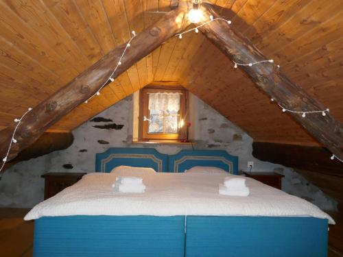 a bedroom with a blue bed in a attic at Holiday Home Rustico Tecc Berbis by Interhome in Castro