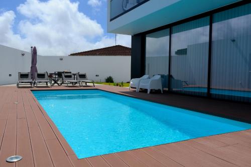 a swimming pool in front of a house at Condessa Home in Ponta Delgada