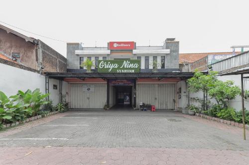 un parcheggio vuoto con un cartello su un edificio di RedDoorz At Pondok Candra a Surabaya