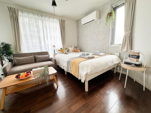 a bedroom with a bed and a couch and a table at nestay inn tokyo ryogoku in Tokyo