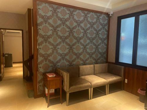 a waiting room with a couch and a window at 寶格儷舍 in Tainan