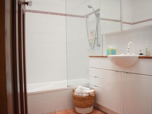 ein weißes Badezimmer mit einem Waschbecken und einer Badewanne in der Unterkunft Maleny Homestead & Cottage in Maleny