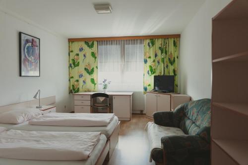 インスブルックにあるソンマーホテル カルウェンダルのベッド2台とソファが備わるホテルルームです。