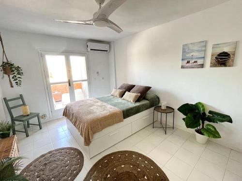 a white bedroom with a bed and a window at Estudio Naturista Indalo in Vera