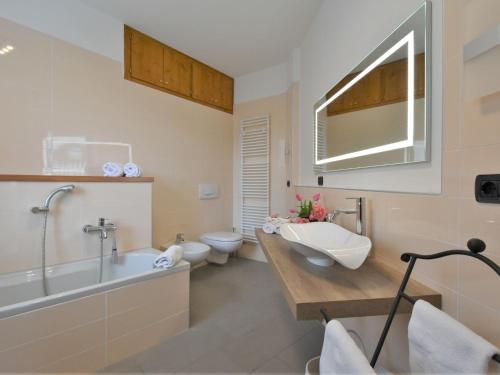 a bathroom with two toilets and a tub and a sink at Apartment Valley View Pool Apartment by Interhome in Ardenno