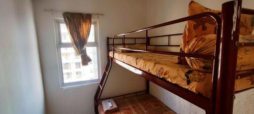 a bedroom with two bunk beds and a window at Spacious & Cozy 27FL - 2BR Apartment West Jakarta in Jakarta