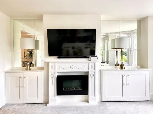 a living room with a fireplace with a tv on top at Lovely Central Horsham Home in Horsham