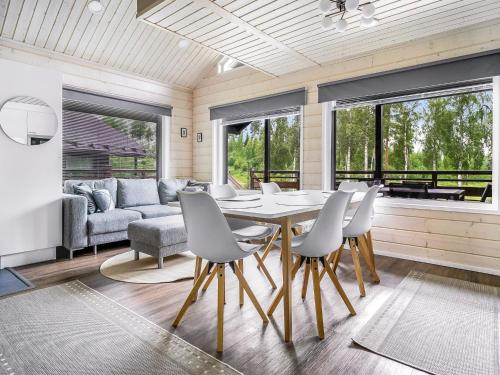 a dining room with a table and chairs and a couch at Holiday Home Himoksen keiju 1 by Interhome in Jämsä