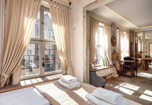 a bedroom with a bed and large windows at Downtown Apartments Old Town Paradise Lost in Gdańsk