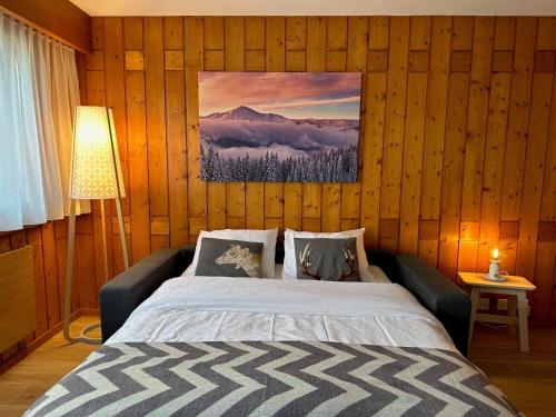 ein Schlafzimmer mit einem Bett und einem Bild an der Wand in der Unterkunft Apartment Parc B428 by Interhome in Champex