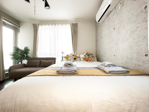 a bedroom with a large bed with towels on it at nestay inn tokyo ryogoku in Tokyo
