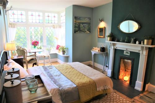 a bedroom with a bed and a fireplace at Dolafon in Llanbedr