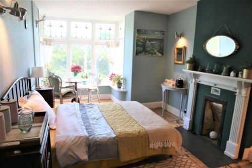 a bedroom with a bed and a fireplace at Dolafon in Llanbedr
