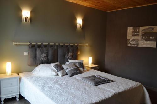 Un dormitorio con una cama con dos almohadas encima. en Gîte la Forge 4 étoiles, en Monségur