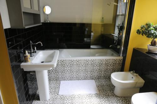 a bathroom with a sink and a tub and a toilet at Dolafon in Llanbedr