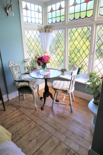 a room with a table and two chairs and a window at Dolafon in Llanbedr
