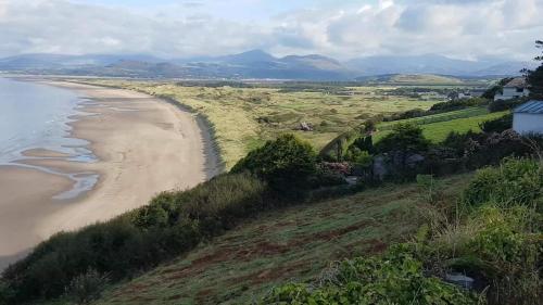 an aerial view of a beach and the ocean at Dolafon in Llanbedr
