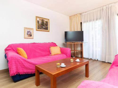 uma sala de estar com um sofá rosa e uma mesa em Apartment Maresto 1 by Interhome em Salou