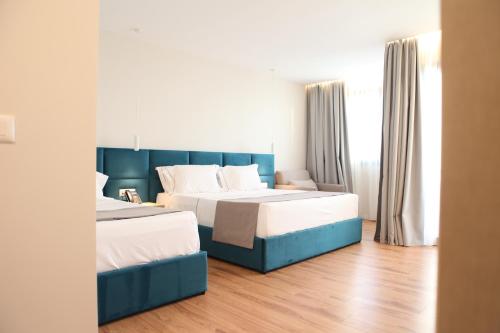 Habitación de hotel con 2 camas y sofá en Volmar Hotel en Durrës