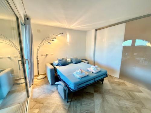 a bedroom with a blue bed with two dolls on it at Villaggio Sherden - Maison & Relais Apartments in Golfo Aranci